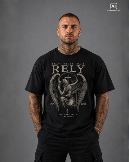 Mann trägt schwarzes T-Shirt mit Frontdruck „RELY – Pray Trust Wait“, Engel Motiv und Psalm 27:14, Christian Streetwear.