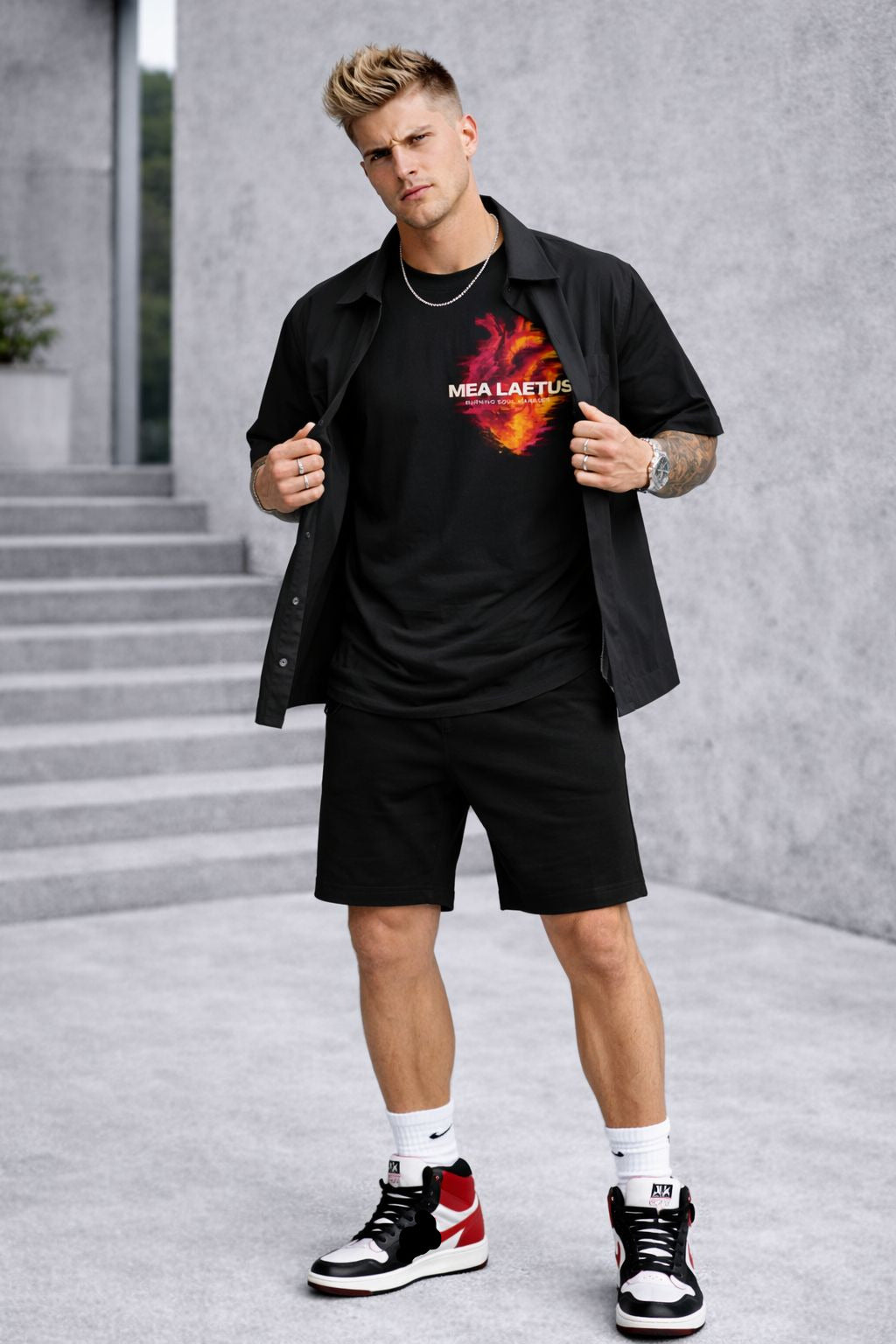 Model trägt schwarzes Burning Soul Tee mit flammendem Herz-Brustprint unter offenem schwarzen Kurzarmhemd.