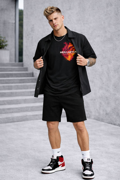Model trägt schwarzes Burning Soul Tee mit flammendem Herz-Brustprint unter offenem schwarzen Kurzarmhemd.
