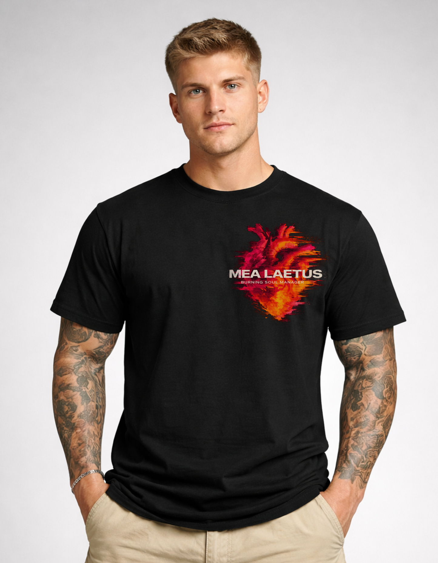 Model trägt schwarzes T-Shirt mit flammendem Herz-Brustprint mit MEA LAETUS Burning Soul Manager Schriftzug.