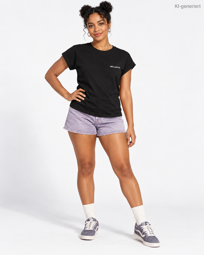 MEA LAETUS Essential Ladies Damen T-Shirt in Schwarz – Studio-Frontansicht mit kleinem weißem Brustlogo und lavendelfarbenen Jeansshorts.