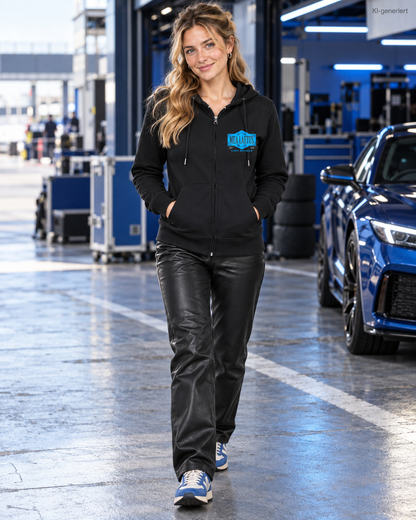 MEA LAETUS Damen Sweatjacke Limitbreaker Emblem Blau in Schwarz – Frontansicht beim Gehen durch das Motorsport-Fahrerlager.