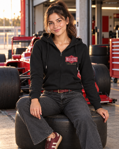 MEA LAETUS Damen Sweatjacke Limitbreaker Emblem Rot in Schwarz – Sitzende Frontansicht vor der Boxengarage mit sichtbarem Brustprint.