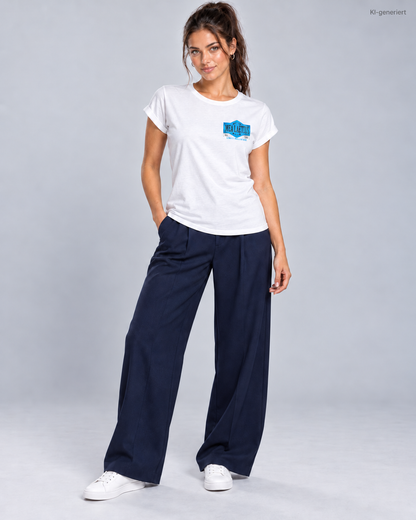 Ganzkörperansicht mit weißem MEA LAETUS Limitbreaker Damen-T-Shirt, dunkelblauer Hose und weißen Sneakern