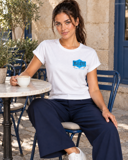 Weißes MEA LAETUS Limitbreaker Damen-T-Shirt mit blauem Brustemblem am Model in einem Straßencafé