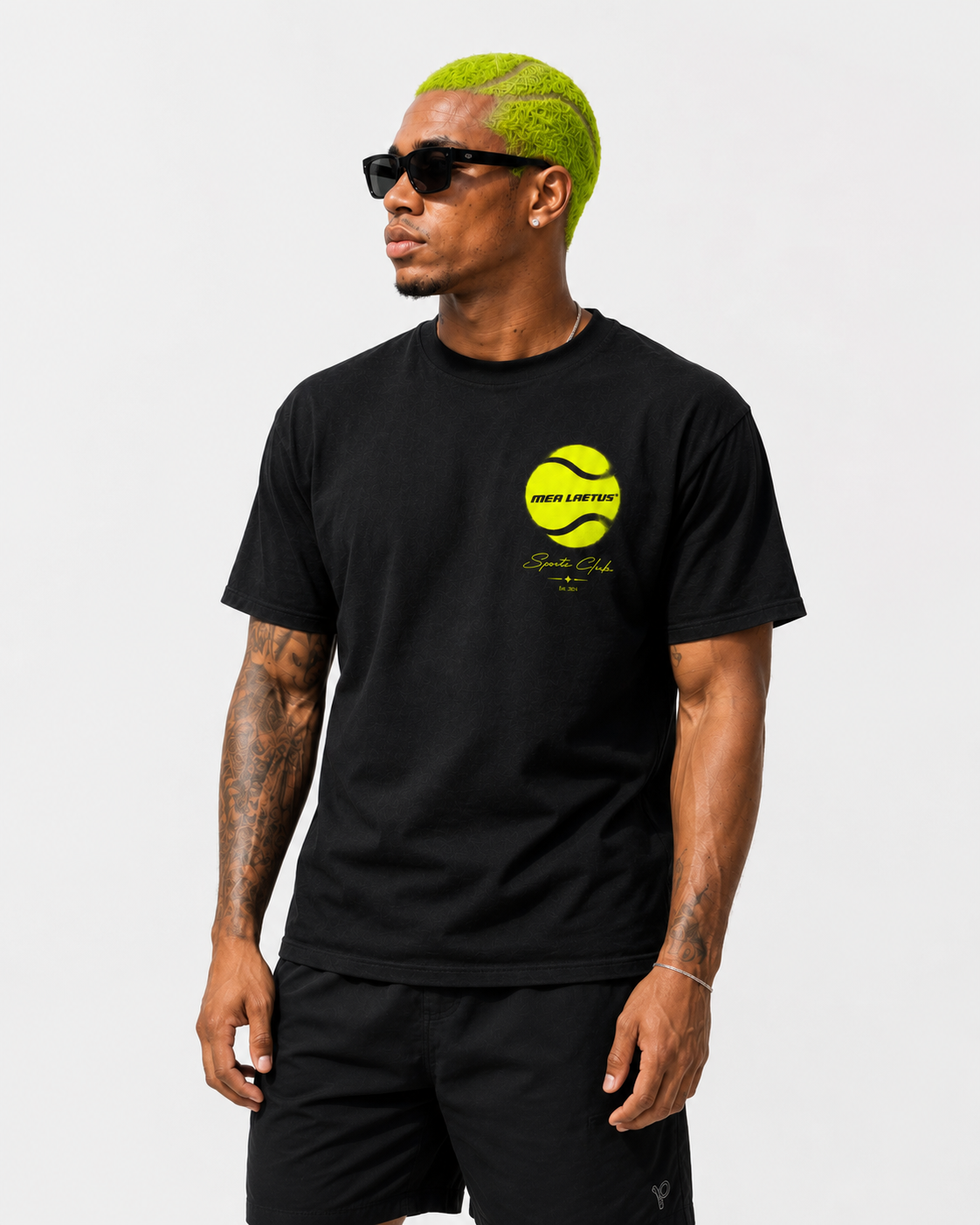 Nahaufnahme des schwarzen MEA LAETUS Tennis T-Shirts für Herren mit neongelbem Tennisball-Frontprint auf der linken Brust.