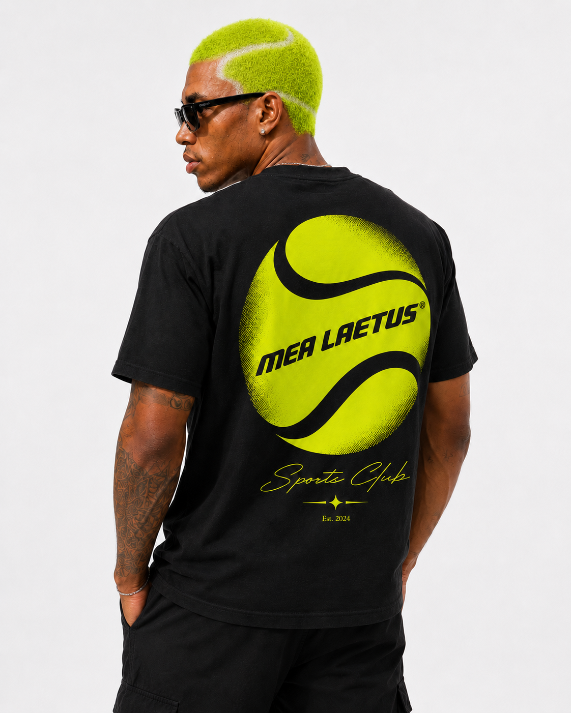 Detailansicht des großen neongelben Tennisball-Backprints mit MEA LAETUS und Sports Club auf einem schwarzen Herren T-Shirt.